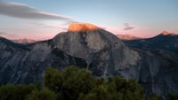 Half dome mountain glowing golden at sunset
