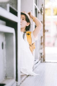 A person in a hat and yellow backpack peeking from behind a doorway