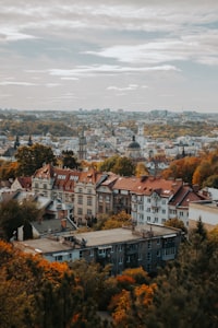 An aerial view of Lviv with historic buildings and autumn trees under a cloudy sky
